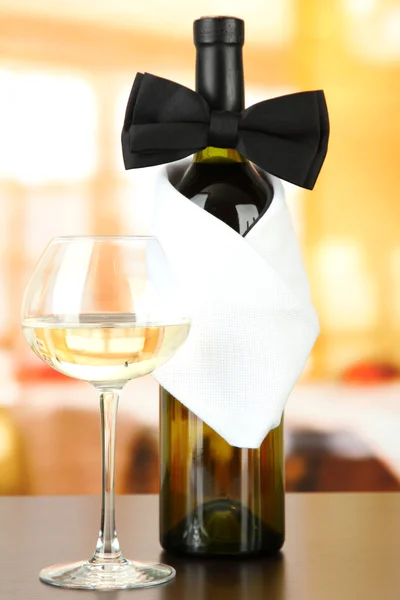 Černý motýlek na láhev vína na světlé pozadí — Stock fotografie
