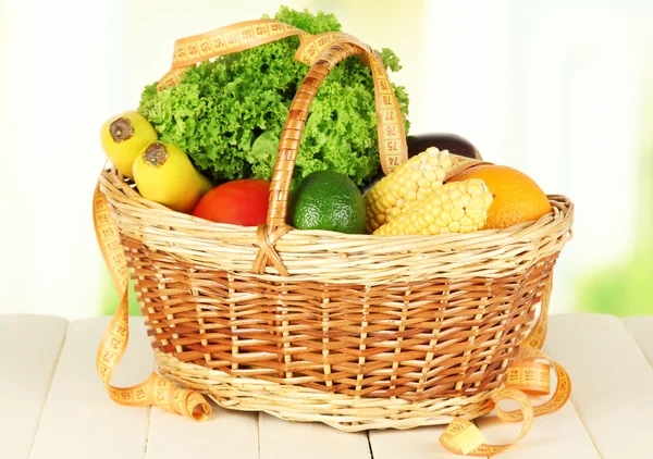 Fresh vegetables in wicker basket on table on light background — Stock Photo, Image