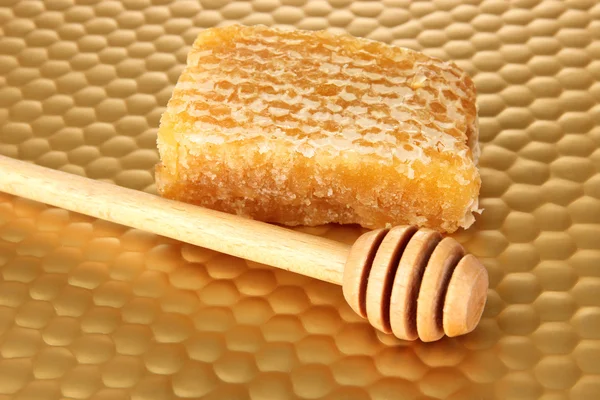 Honey comb and honey on bright yellow background — Stock Photo, Image