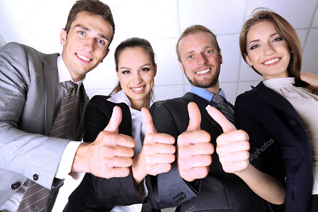Business team showing thumbs up in office