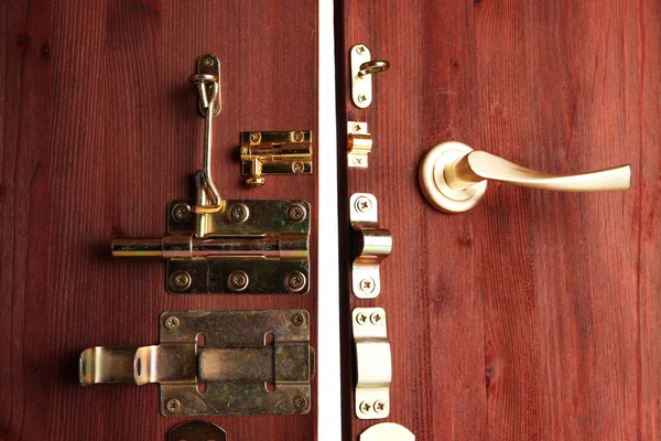 Металлические болты, защелки и крючки в деревянной открытой двери крупным планом — стоковое фото