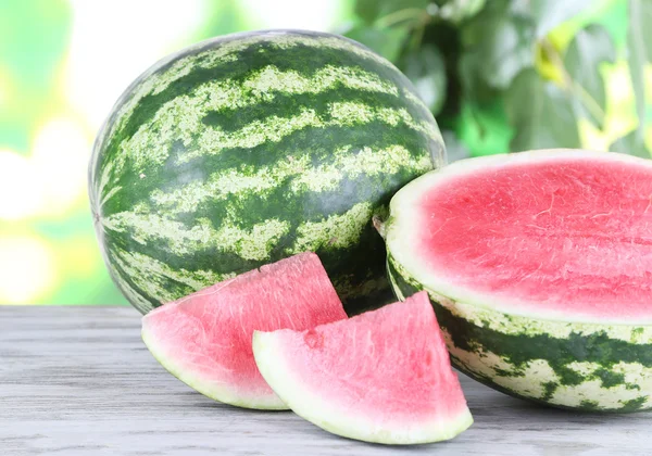 Ripe watermelons on wooden table on nature background — Stock Photo, Image