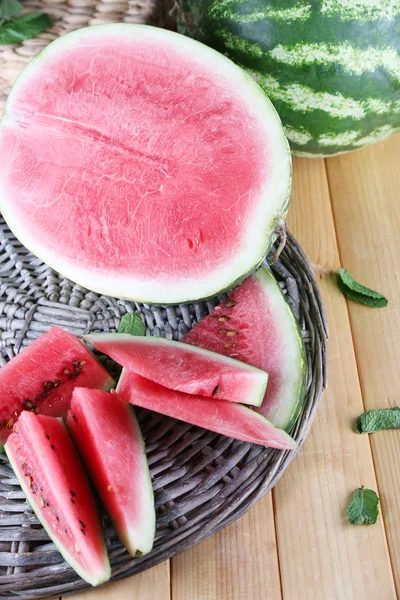 Reife Wassermelonen auf Korbblech auf Holztisch — Stockfoto