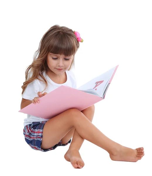 Menina sentada no chão com livro isolado em branco — Fotografia de Stock