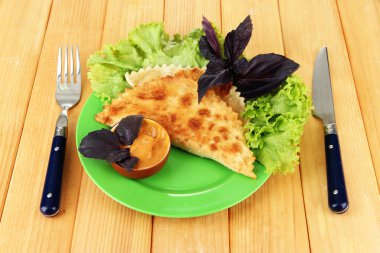 ahşap zemin üzerinde plaka üzerinde taze otlar ile lezzetli chebureks