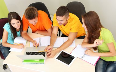 Grup genç öğrenci oturma odasında