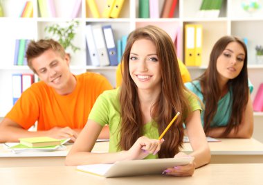 Kütüphanede oturan genç öğrenci grubu