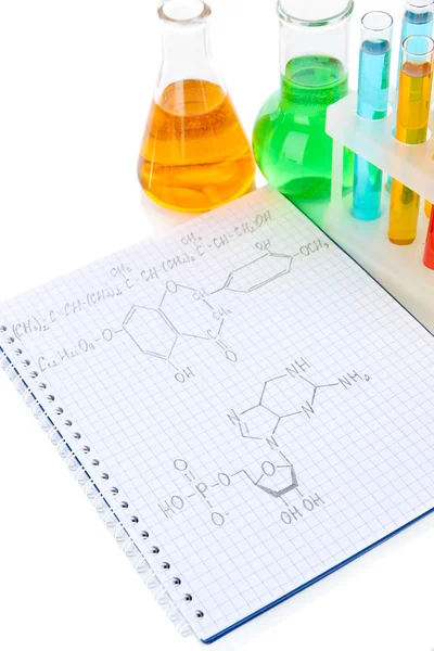 Provette con liquidi colorati e formule isolate su bianco — Foto Stock