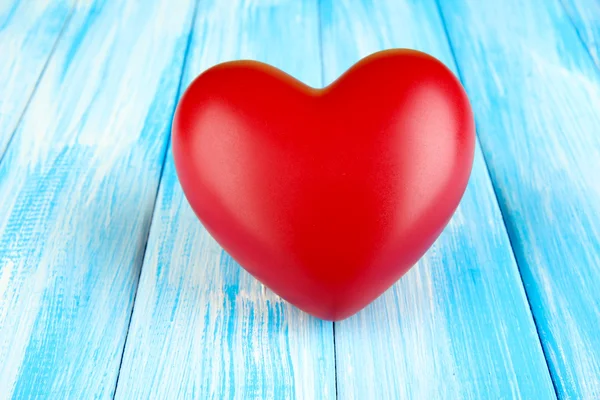 Coração vermelho decorativo na cor de fundo de madeira — Fotografia de Stock