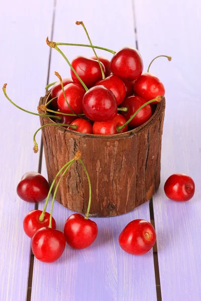 Bayas de cereza en maceta sobre mesa de madera de cerca —  Fotos de Stock