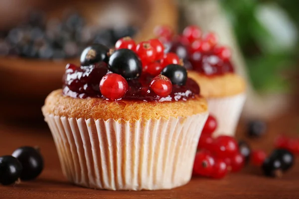 Ahşap masa üzerinde meyveleri ile lezzetli muffins — Stok fotoğraf