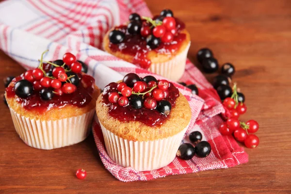 Leckere Muffins mit Beeren auf Holztisch — Stockfoto