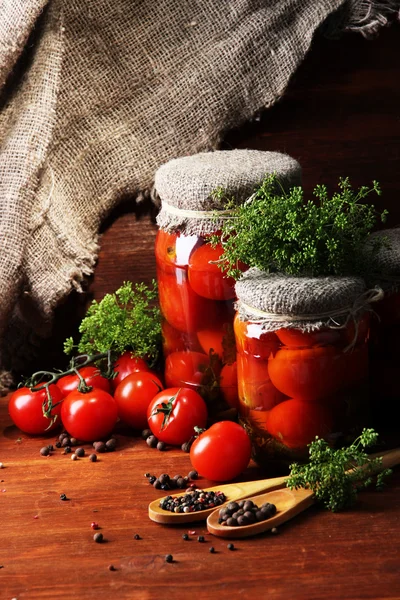 Leckere Tomaten aus der Dose und frisch auf dem Holztisch — Stockfoto