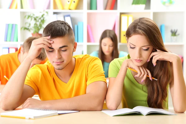 Gruppe junger Studenten sitzt in der Bibliothek — Stockfoto