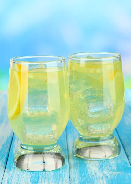 Heerlijke limonade op tafel op blauwe achtergrond — Stockfoto