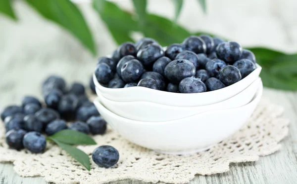 Blaubeeren in Tellern auf Serviette auf Holzgrund — Stockfoto