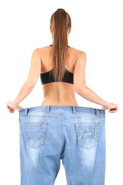 Slim girl in big jeans isolated on white — Stock Photo, Image