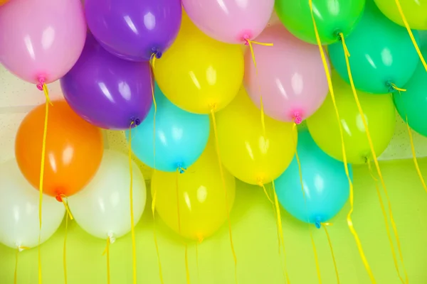 Färgglada ballonger på grön vägg bakgrund — Stockfoto