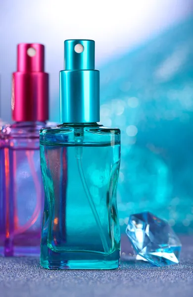 Women perfume in beautiful bottles on blue background — Stock Photo, Image