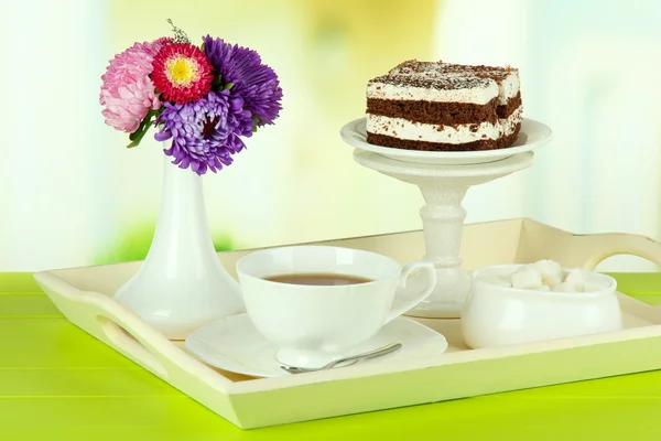 Cup of tea with cakes on wooden tray on table in room — Stock Photo, Image