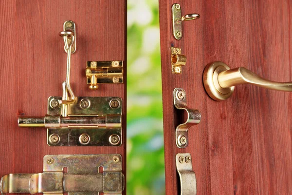 Parafusos metálicos, travas e ganchos em porta aberta de madeira close-up — Fotografia de Stock