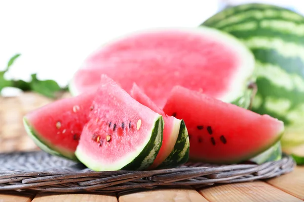 Reife Wassermelonen auf Korbblech auf Tisch auf Holzhintergrund — Stockfoto