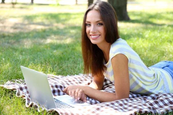 Vacker ung flicka med laptop i park — Stockfoto