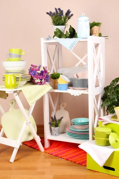 Красиві білі меблі з посудом і декором, на кольоровому тлі стін — стокове фото