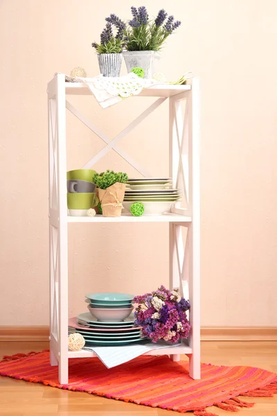 Magnifiques étagères blanches avec vaisselle et décoration, sur fond de mur de couleur — Photo