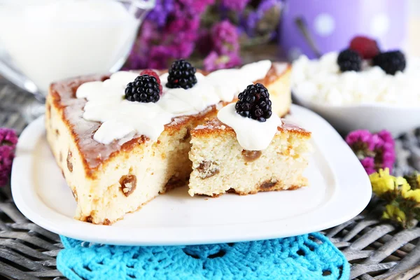 Cheese casserole with raisins on plate on napkin on wooden table close-up — Stock Photo, Image