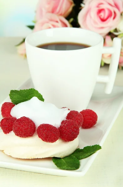 Tasty meringue cake with berries and cup of coffee, on wooden table — Stock Photo, Image