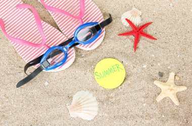 kompozisyon ile flip floplar, kum zemin üzerine koruyucu gözlük