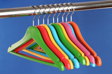 mavi arka plan üzerinde renkli elbise askıları