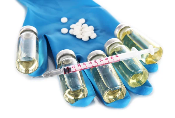 Medical bottles, tablets and syringe on hand on light gray tone — Stock Photo, Image