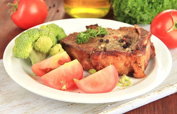 Piece of fried meat on plate on wooden table close-up — Stock Photo, Image