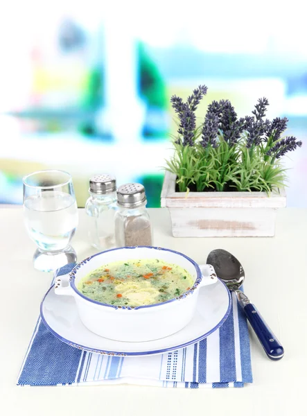 Sopa en plato sobre servilleta sobre tabla de madera sobre fondo de ventana — Foto de Stock