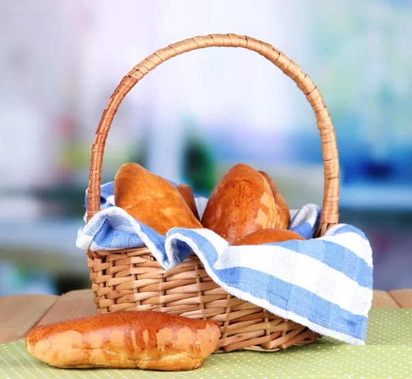 Fresh baked pasties in wicker basket, on bright background — Stock Photo, Image