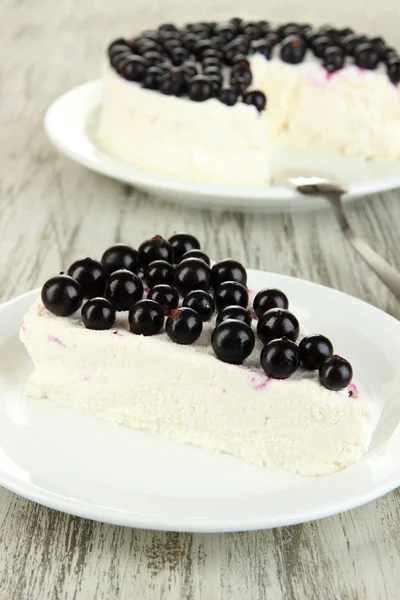 Cheesecake with fresh berries on white plate on wooden table closeup — Stock Photo, Image