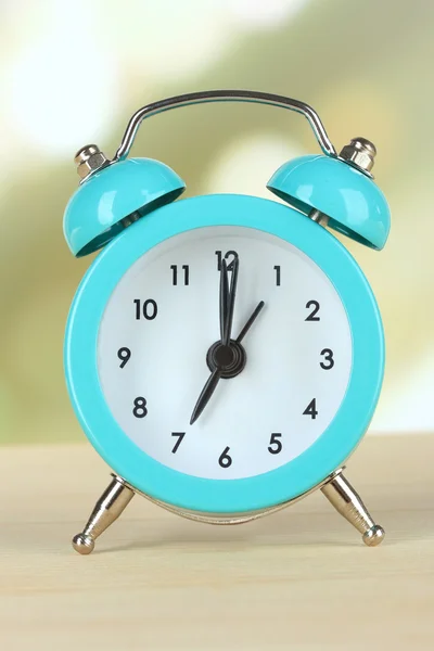 Alarm clock on table on light background — Stock Photo, Image