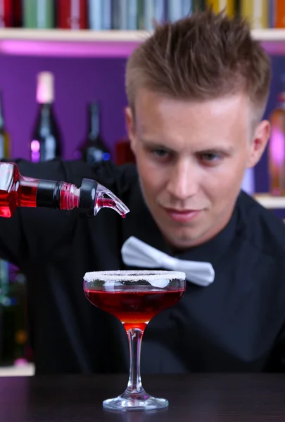 Portrait of handsome barman preparing cocktail, at bar — Stock Photo, Image