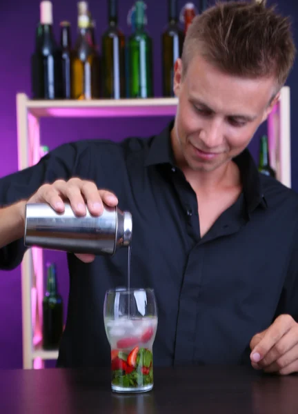 Portrait de beau barman préparant un cocktail, au bar — Photo