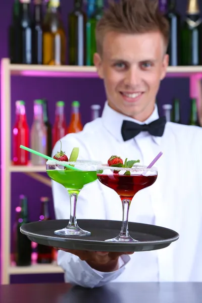 Portrait of handsome barman with different cocktails cocktail, at bar — Stock Photo, Image