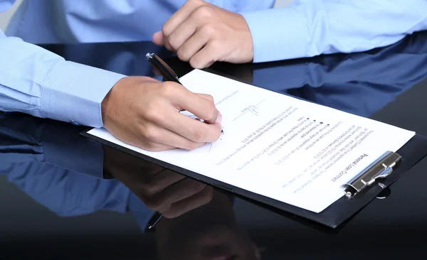 Empresario escribiendo sobre documento en primer plano de la oficina — Foto de Stock