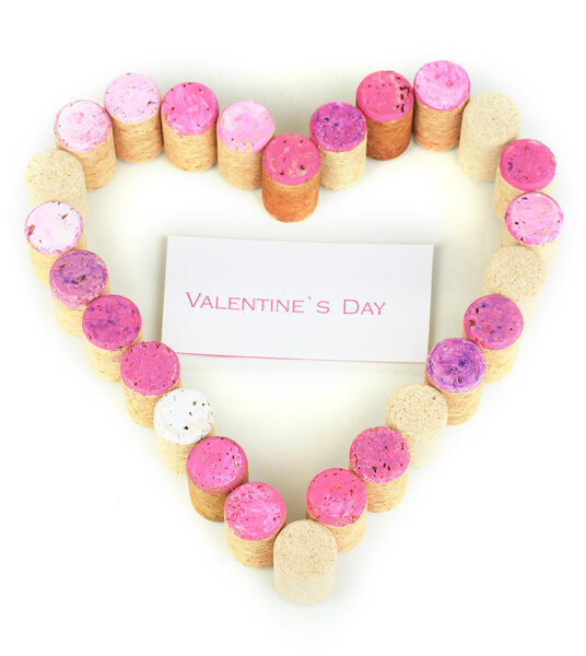 Пробки для вина выложены в виде сердца, изолированного на белом
