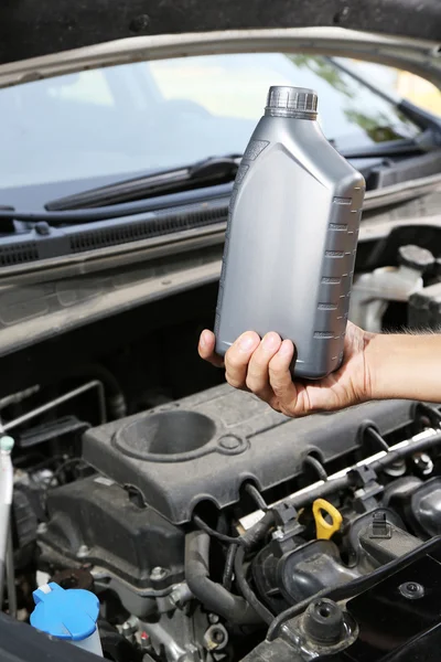 Automechaniker hält Motoröl in der Hand — Stockfoto