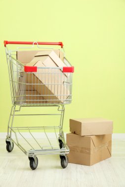 karton, yeşil duvar arka plan üzerinde alışveriş sepeti