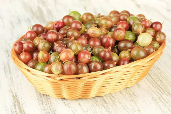 Verse kruisbessen in rieten mand op tabel close-up — Stockfoto