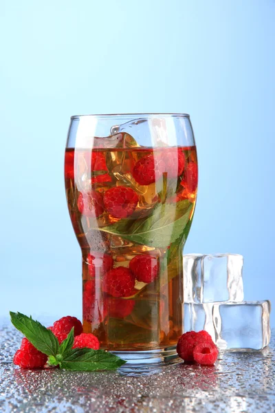 Iced tea with raspberries and mint on blue background — Stock Photo, Image