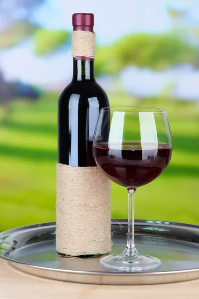Kieliszek do wina i butelka na jasnym tle — Zdjęcie stockowe