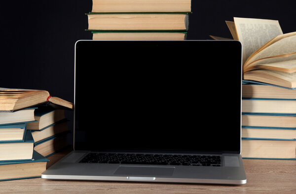Ноутбук на фоне книг
